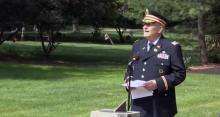 Retired Army Lt. Col. Barnard Kemter in uniform speaking a microphone.