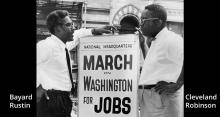 Bayard Rustin (l) and Cleveland Robinson standing on either side of a sidewalk sign that says "National Headquarters  March on Washington for Jobs and Freedom